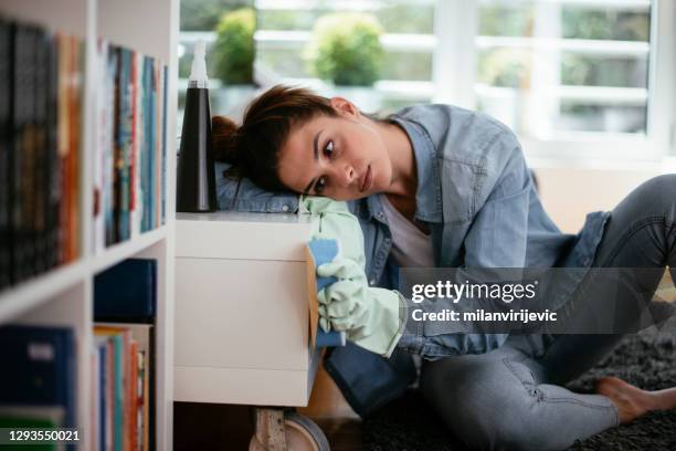 junge traurige frau reinigungshaus. - hausarbeit stock-fotos und bilder