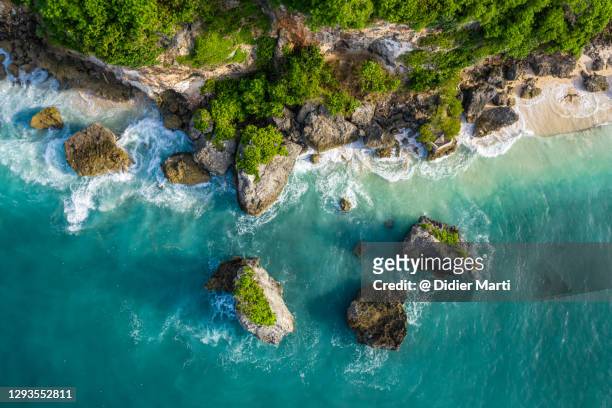 overhead drone view of the dramatic coast of the bukit peninsula in bali, indonesia - wasserrand stock-fotos und bilder
