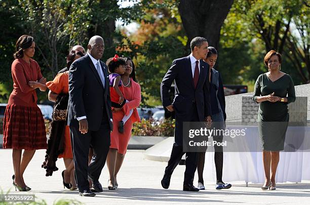 President Barack Obama, walks hand-in-hand with daughter Malia as he is followed by first lady Michelle Obama, Harry Johnson, president and CEO of...