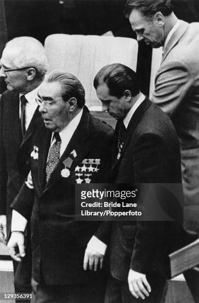 Soviet premier Leonid Brezhnev is lead from the podium by East German premier Erich Honecker after Brezhnev announced unilateral troop strength...