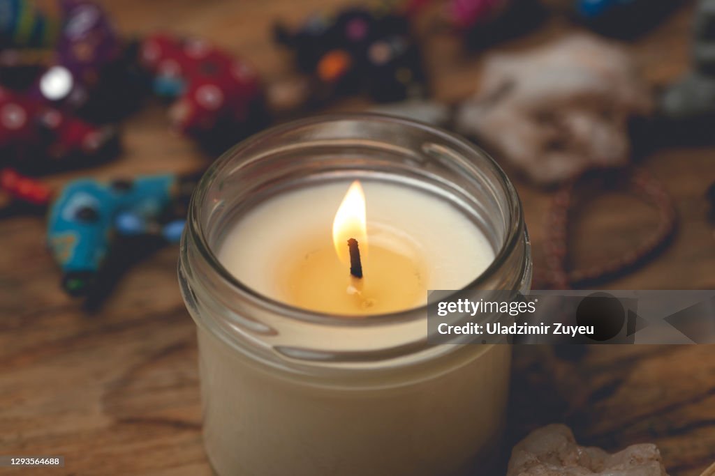 Homemade candle in a glass candlestick on a wooden table. Home comfort, aromatherapy and relaxation