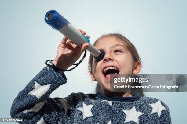 little girl looking through a telescope - looking through an object stock pictures, royalty-free photos & images