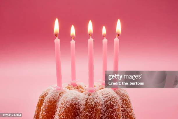 still life of birthday cake with pink candles against pink background - birthday candle stock pictures, royalty-free photos & images