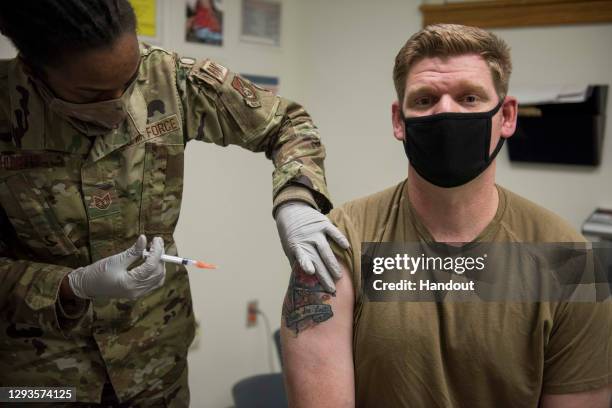 In this handout image provided by United States Forces Korea, U.S. Air Force Sgt. Andrew Kehl receives a dose of the Moderna COVID-19 vaccine at...