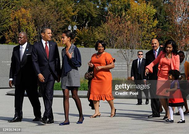 President Barack Obama, walks hand-in-hand with daughter Malia as he is followed by Harry Johnson , president and CEO of the MLK National Memorial...