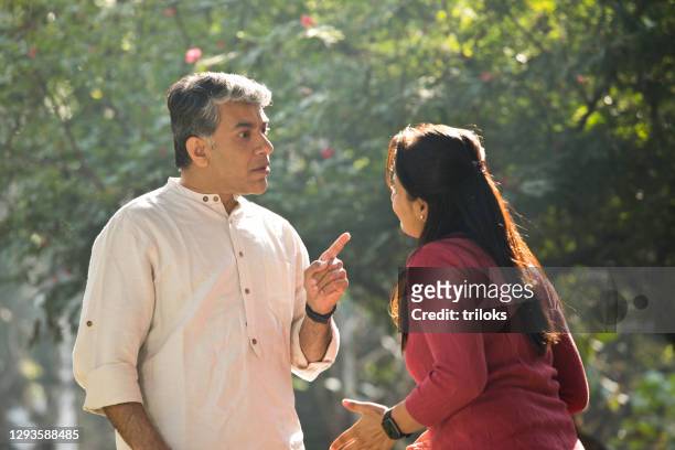 couple having an argument at park - fighting stock pictures, royalty-free photos & images