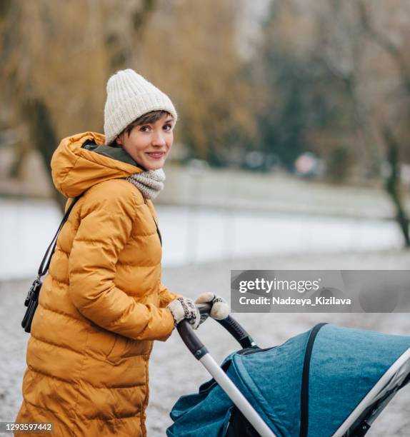 winterspaziergang - mum pushing pram stock-fotos und bilder