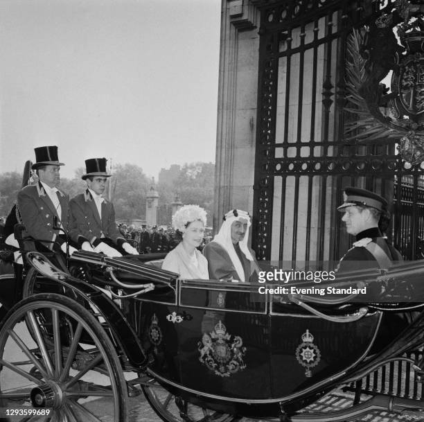 Queen Elizabeth II and Prince Philip arrive back at Buckingham Palace by coach with King Faisal of Saudi Arabia during his official visit to London,...