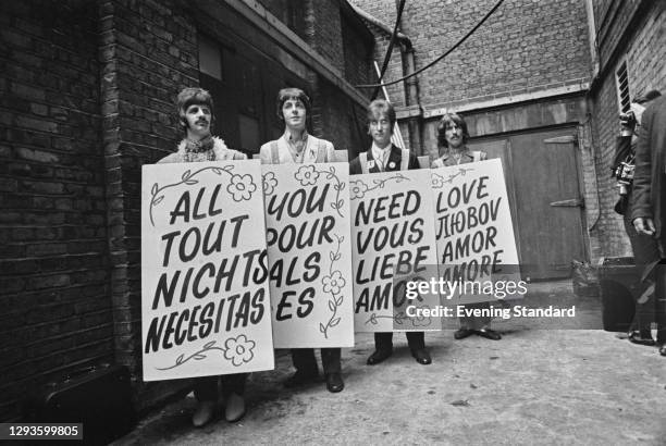 The Beatles hold up sandwich boards in different languages during the Our World satellite broadcast of the song 'All You Need is Love' from Abbey...