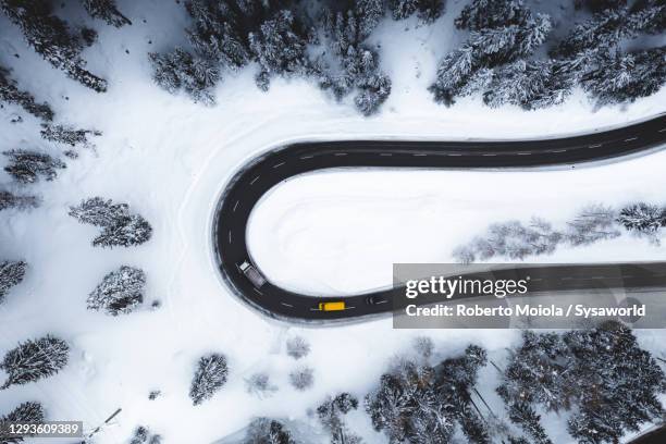 cars traveling on hairpin bends of snowy road from above - hairpin curve stock pictures, royalty-free photos & images