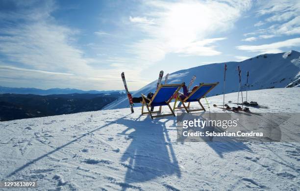 lounge chairs, mountain skis with climbing skins, ski resort. - vacanza sulla neve foto e immagini stock