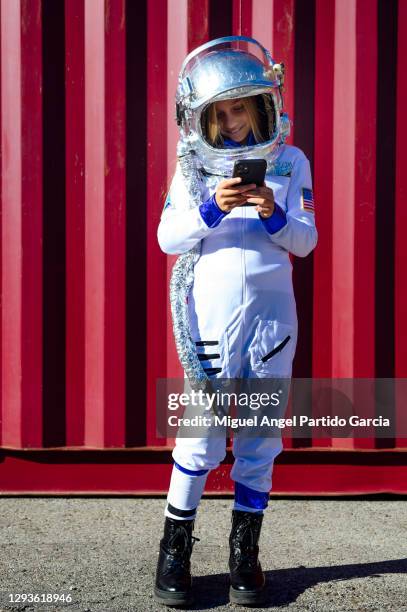 front view of girl in spacesuit using smartphone while standing - child in space suit stock pictures, royalty-free photos & images