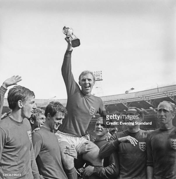 England captain Bobby Moore holds up the Jules Rimet trophy as he is carried on the shoulders of his team-mates after their 4-2 victory over West...