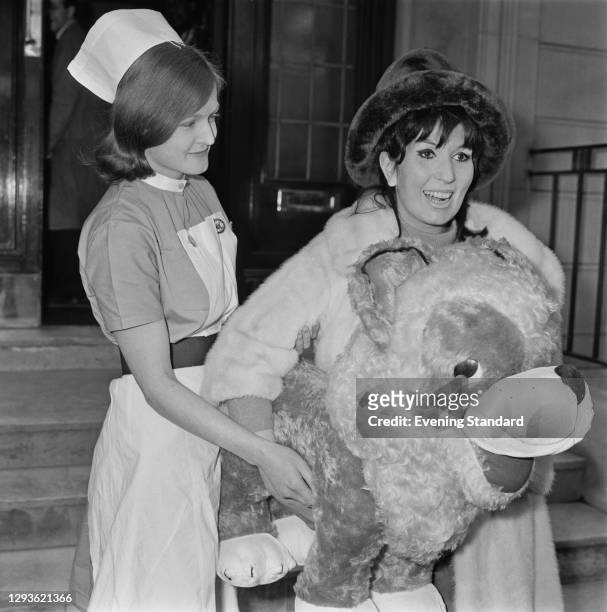 English singer Alma Cogan leaves hospital after an operation, UK, 5th March 1966. She died later that year of cancer.