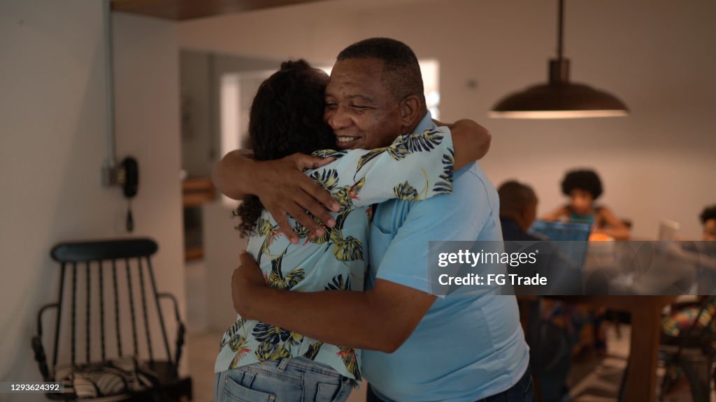 Father embracing daughter at home