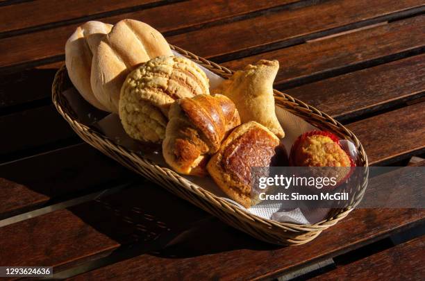 sweet and savoury bread and pastry selection in a wicker basket on a wooden table top - sweet bread fotografías e imágenes de stock