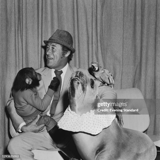 English actor Rex Harrison with a baby chimp, a sea lion and a parrot on the set of the film 'Doctor Dolittle', UK, June 1966.