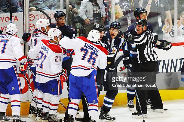 Linesmen separate P.K. Subban of the Montreal Canadiens and Blake Wheeler of the Winnipeg Jets as their teammates look on during a third period scrum...