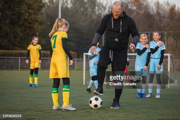 soccer father coaching football daughter's team during a training session - club football stock pictures, royalty-free photos & images