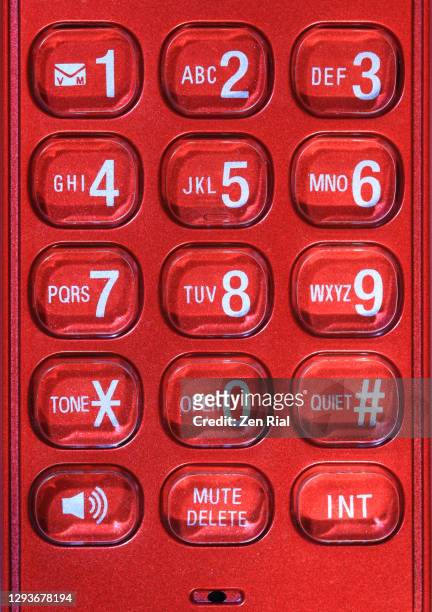 close up of a vibrant red cordless handset phone showing numbers and letters on buttons - phone number stock pictures, royalty-free photos & images