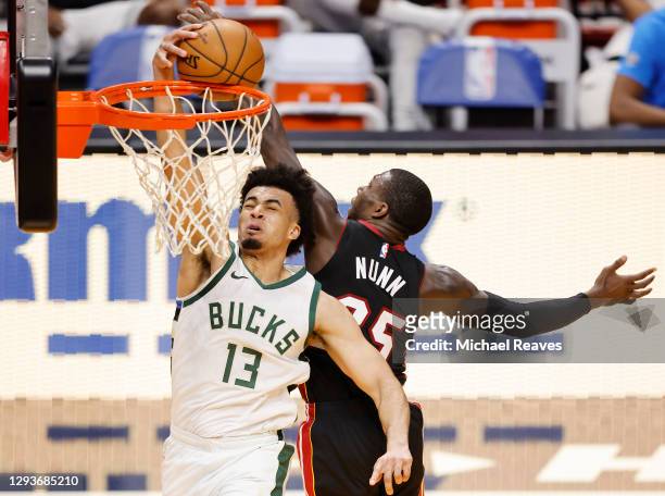 Kendrick Nunn of the Miami Heat blocks a dunk by Jordan Nwora of the Milwaukee Bucks during the fourth quarter at American Airlines Arena on December...