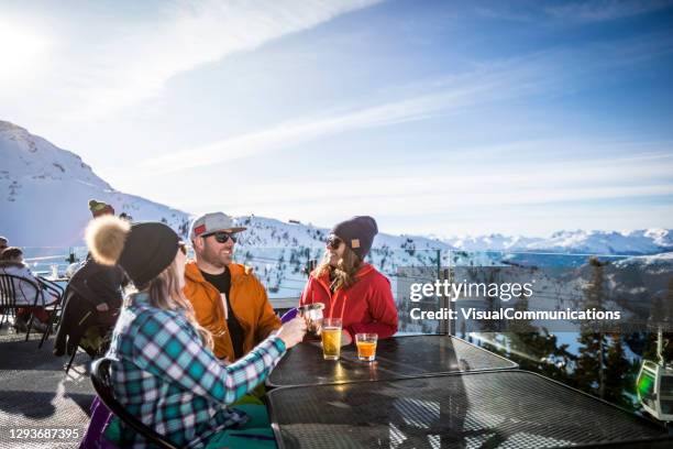 groep vrienden die van apres-ski bij bovenkant van de berg van whistler genieten. - après ski stockfoto's en -beelden