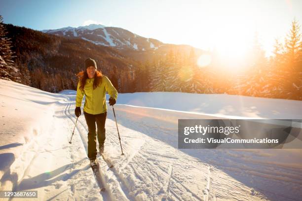 ensam kvinna längdskidåkning vid solnedgången i skidort. - cross country skiing bildbanksfoton och bilder