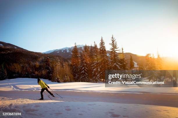 alone woman cross country skiing at sunset in ski resort. - lost lake stock pictures, royalty-free photos & images