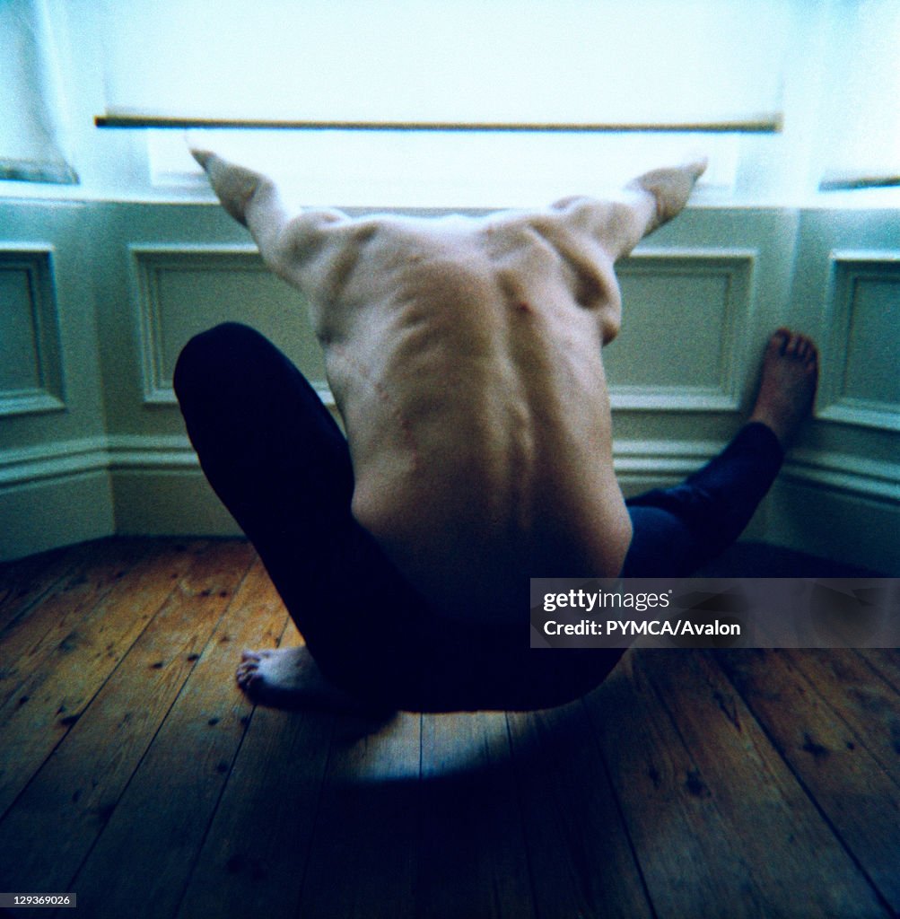 Man restraining himself against window ledge, UK, 2005