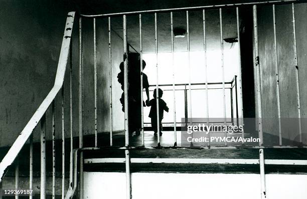 Silhouette of a mother with her children in the hallway of a block of flats on a housing estate Croydon UK 1990's