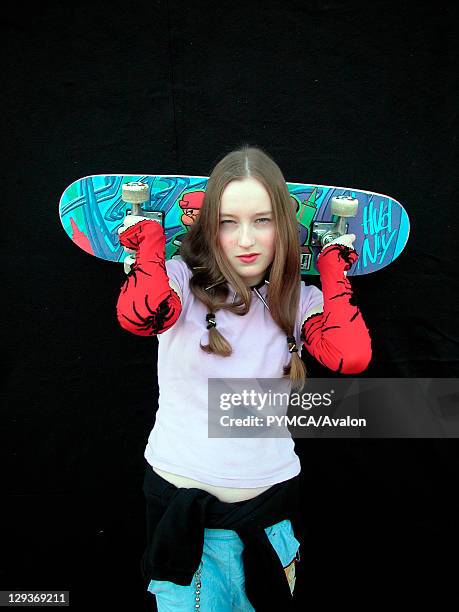 Girl holding up a skateboard