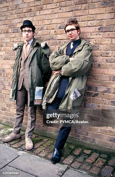 Two Mods in suits and parkas, leaning against a wall, London, UK, 2000's