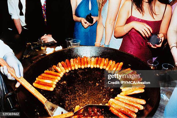 Hot Dogs, Sausages on Barbeque Surrounded by People, UK 2000's