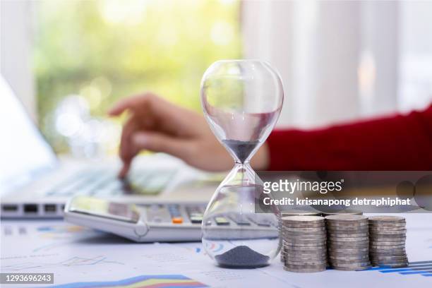 time management ideas invest ,money and hourglass,business concept - due fotografías e imágenes de stock