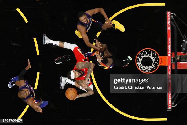 Brandon Ingram of the New Orleans Pelicans attempts a shot defended by Deandre Ayton, Mikal Bridges and Chris Paul of the Phoenix Suns during the...