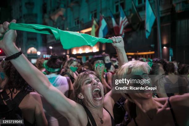 Pro-choice demonstrator hold her green kerchief celebrating after the right to an abortion is legalized on December 29, 2020 in Buenos Aires,...