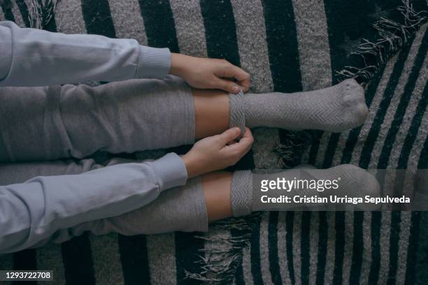 girl puts on some socks on a cold day - hot spanish women stock pictures, royalty-free photos & images