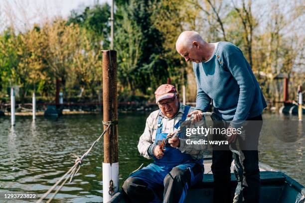 two senior man working together in boathouse - man reliable learning stock pictures, royalty-free photos & images