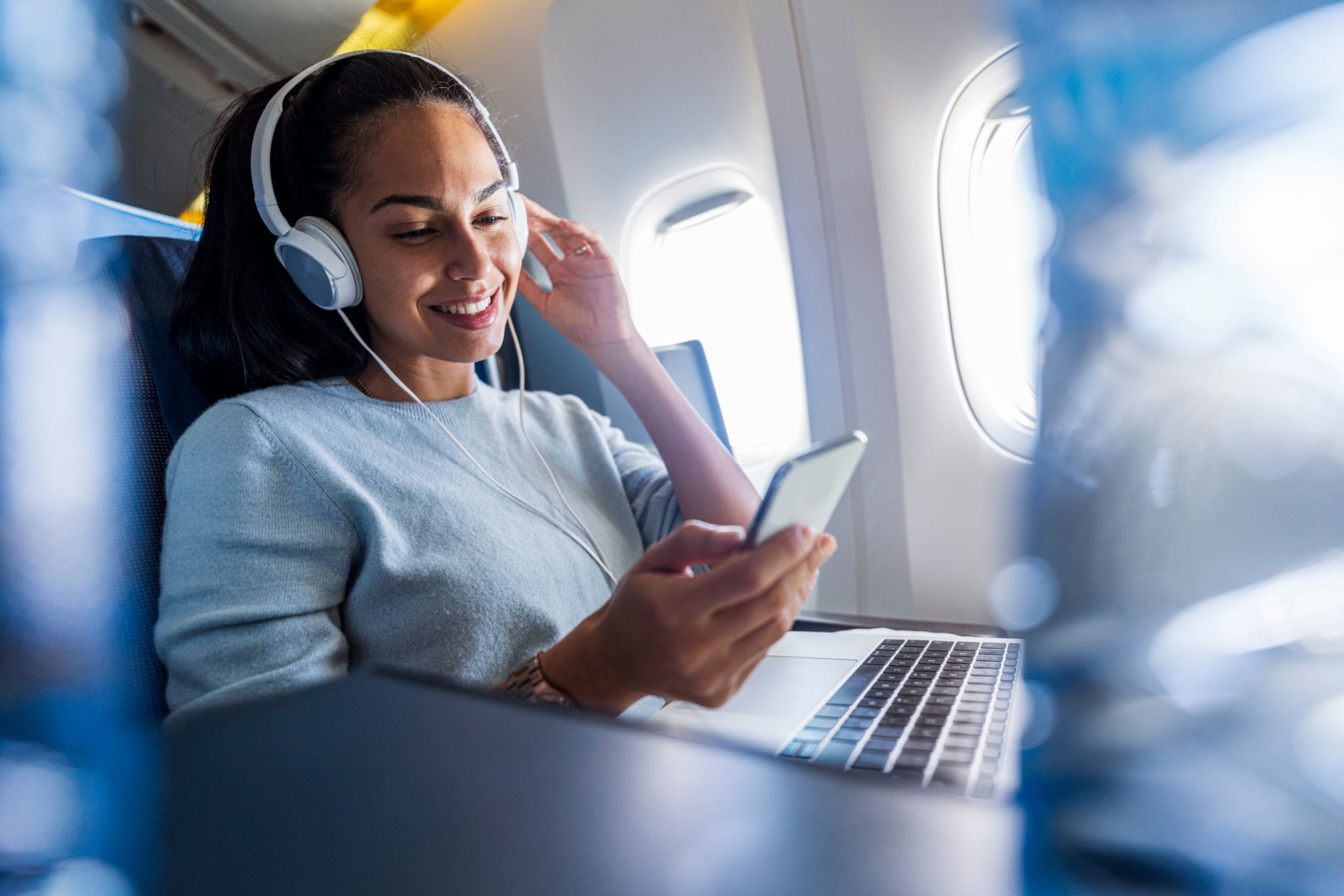 Woman with headphones on a plane listening music Woman with headphones on a plane listening music