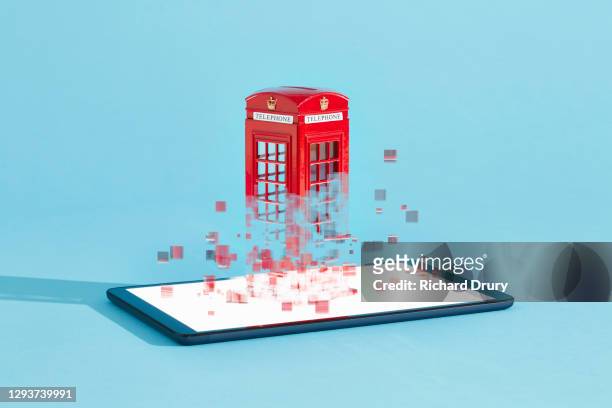a british telephone box emerging from a digital tablet - appearance foto e immagini stock