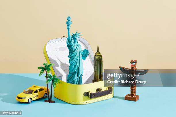 a collection of travel souvenirs in and around a suitcase - figurine stock pictures, royalty-free photos & images