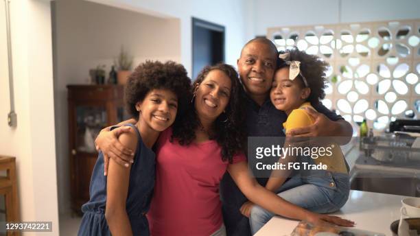 portrait of a happy family together at home - afro friends home stock pictures, royalty-free photos & images