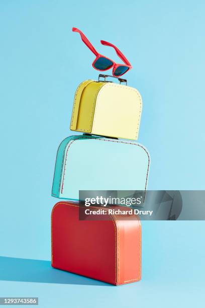 a stack of suitcases with a pair of sunglasses balanced on the top - group studio shot stock pictures, royalty-free photos & images