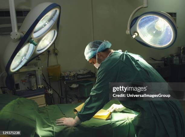 Hospital surgeon looking over patients notes before surgery