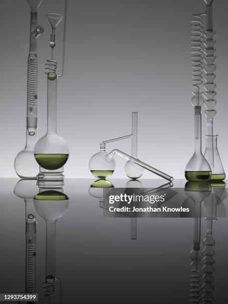 green liquid in glass science flasks - attrezzatura per la ricerca foto e immagini stock