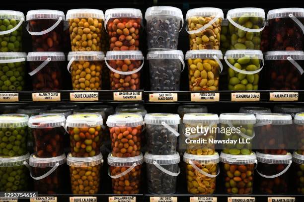 Variety of olives in plastic containers on a shelf at Uncle Giuseppe's grocery store in North Babylon, New York on December 29, 2020.