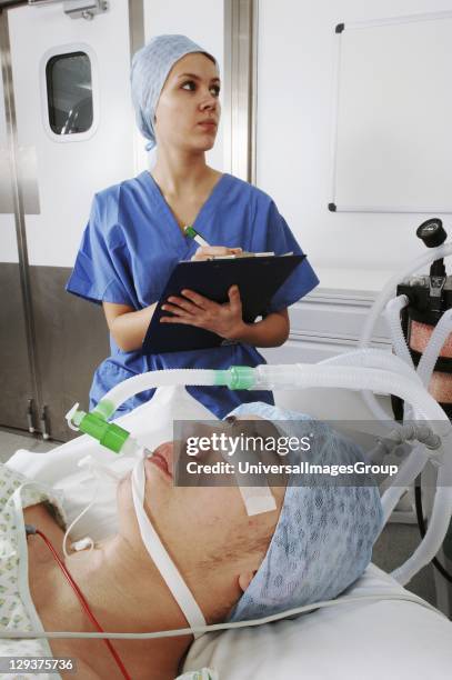 Female anesthetist monitoring patients condition during operation