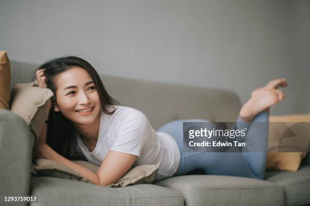 aziatische chinese mooie vrouw die op bank ligt ontspan het nemen van een onderbreking na training in de ochtend - legging stockfoto's en -beelden