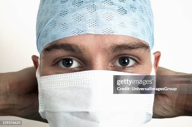 Close up of face of young doctor wearing blue surgical cap