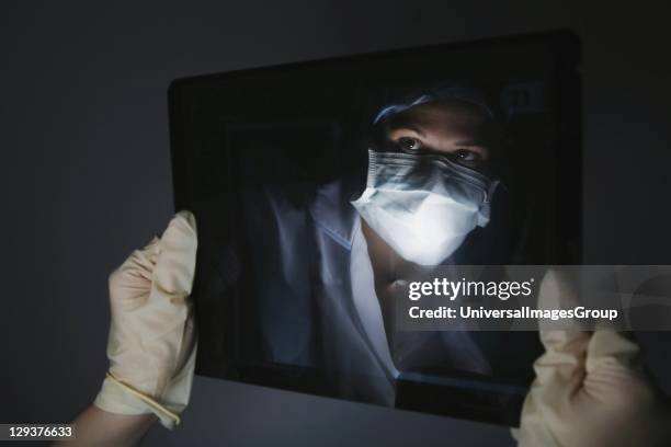 Young surgeon examining X-Ray